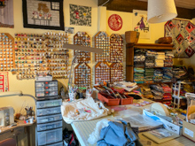 Cutting table, thread wall, notions and quilt fabric neatly folded & color sorted